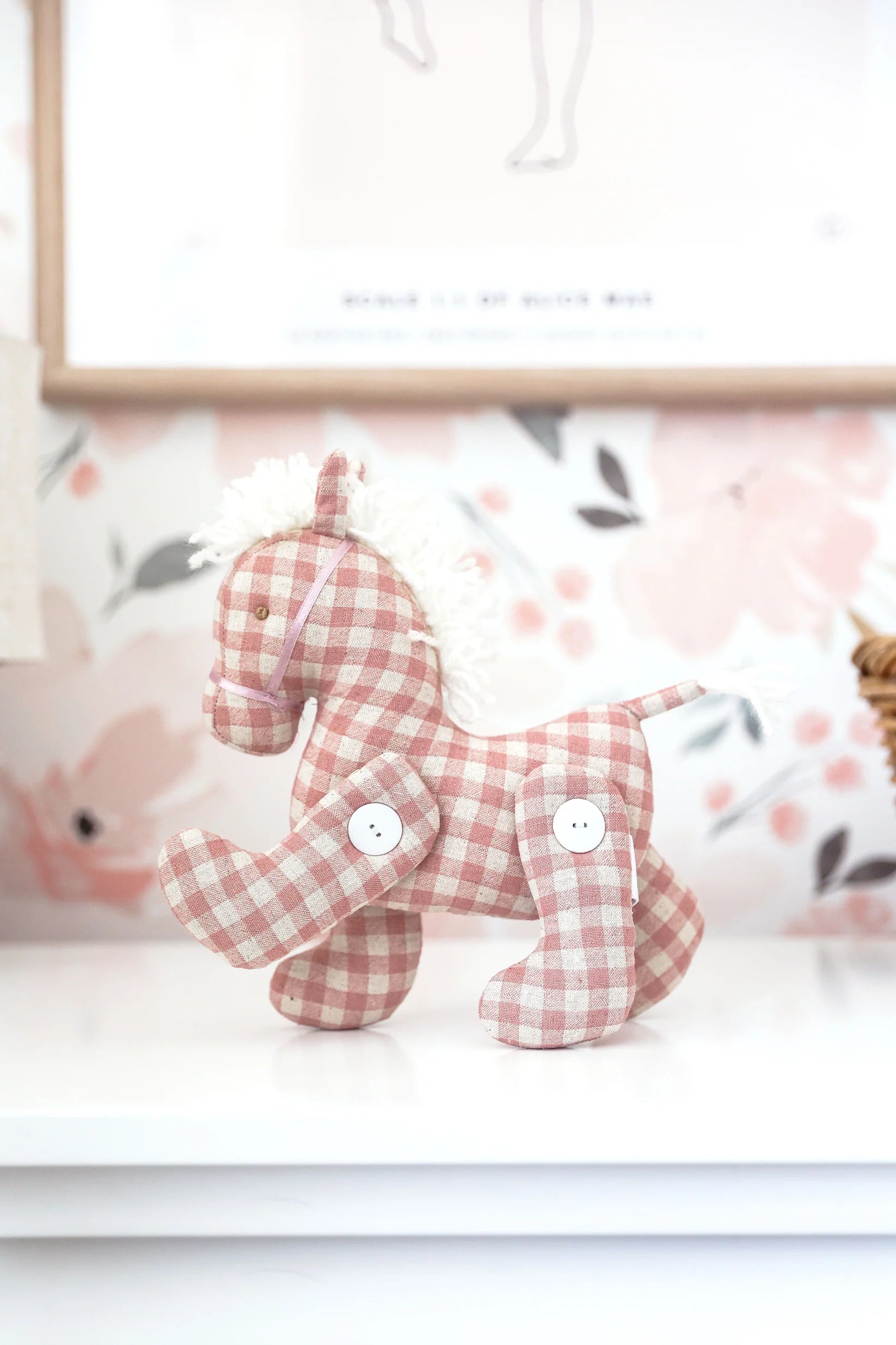 Alimrose Jointed Pony 22cm in rose check fabric displayed on shelf with floral wallpaper background.