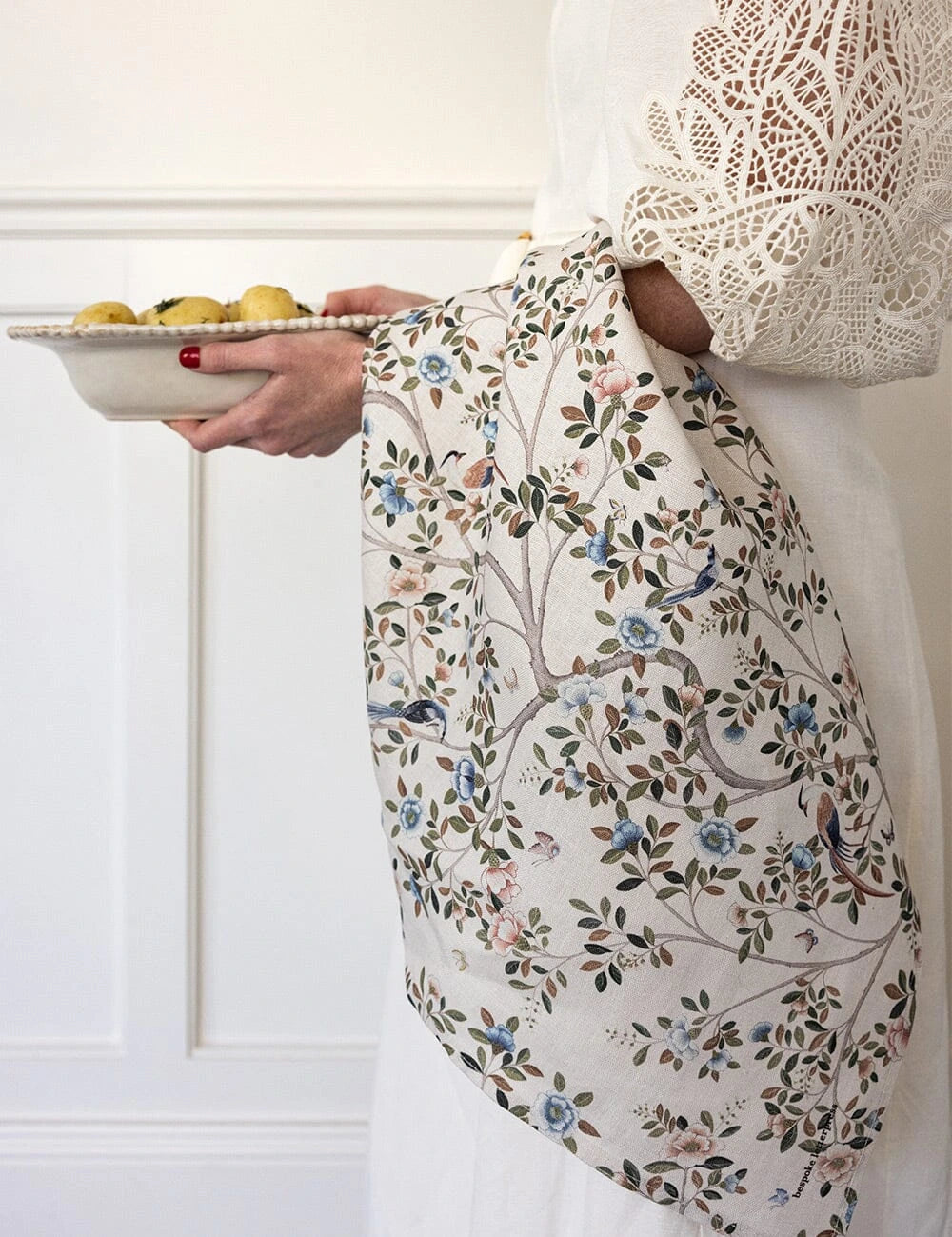 Bespoke Letterpress Camellia Tree Linen Tea Towel draped over arm with floral and bird motif