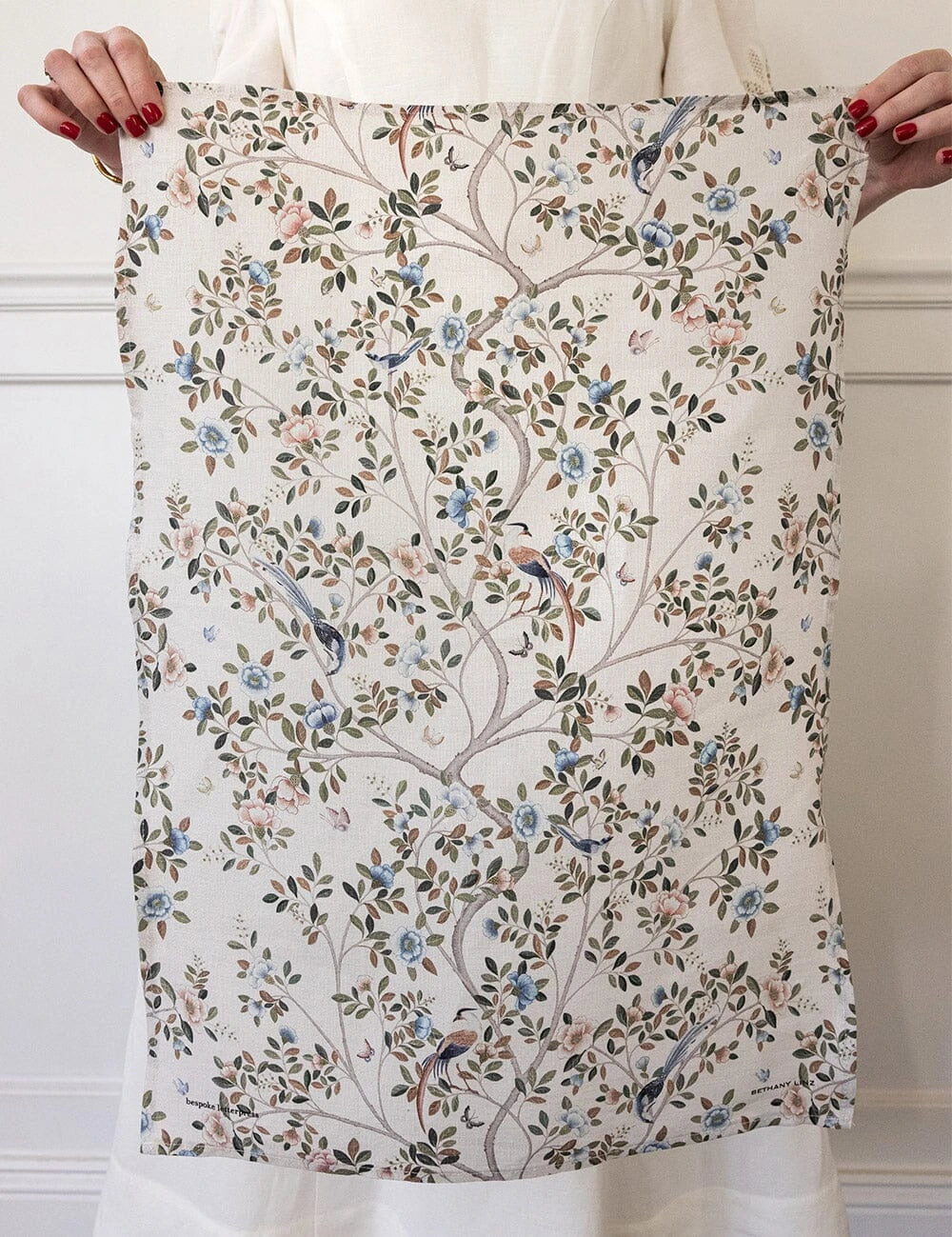 Bespoke Letterpress Camellia Tree Linen Tea Towel with floral and bird design held up for display
