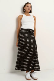 Black white polka dot satin maxi skirt styled with white tank top casual chic outfit bias cut silhouette comfortable elastic waist timeless wardrobe essential