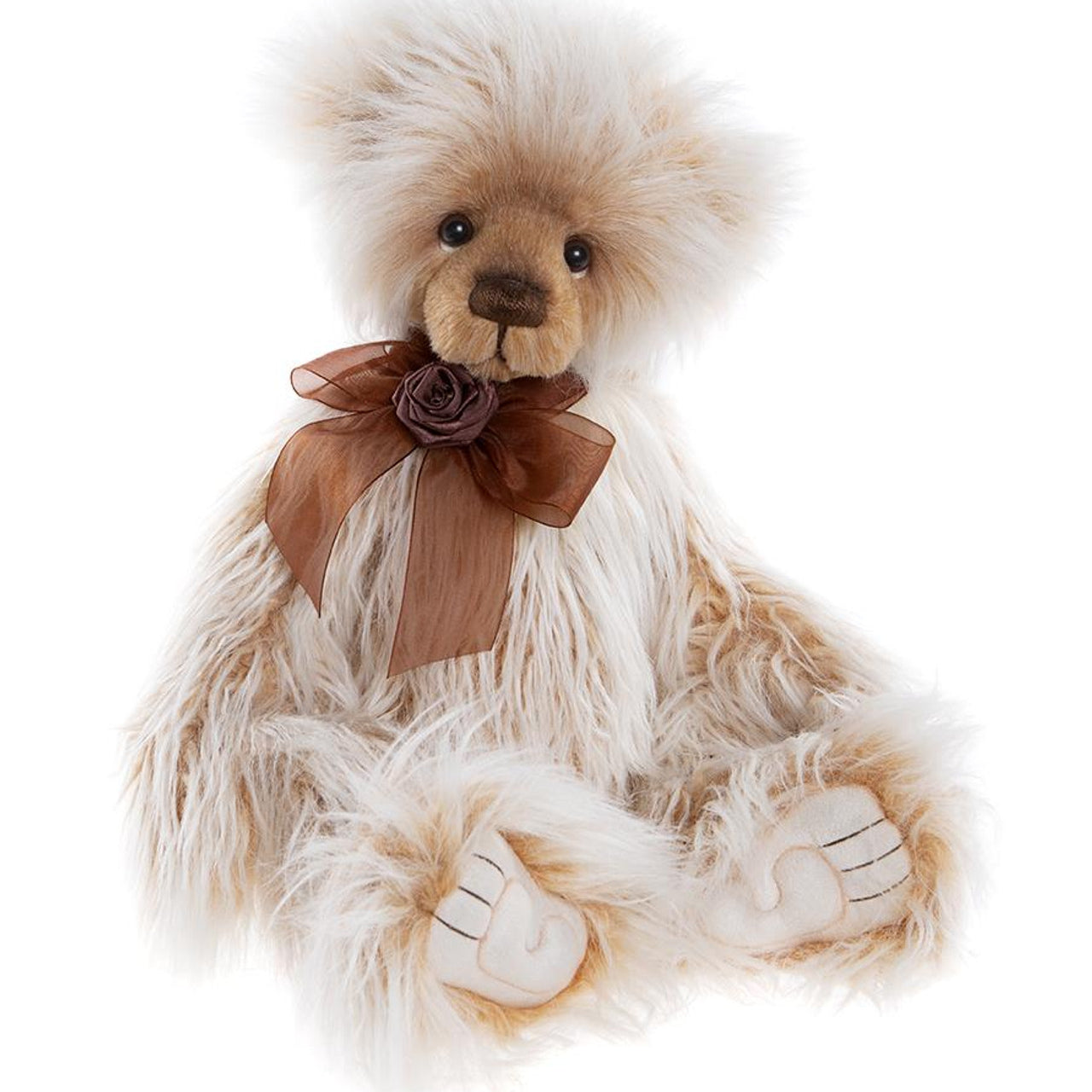 Charlie Bears Ari plush bear with fluffy cream and caramel fur, dark eyes, sculpted paw pads, and a brown organza bow with a rose detail.