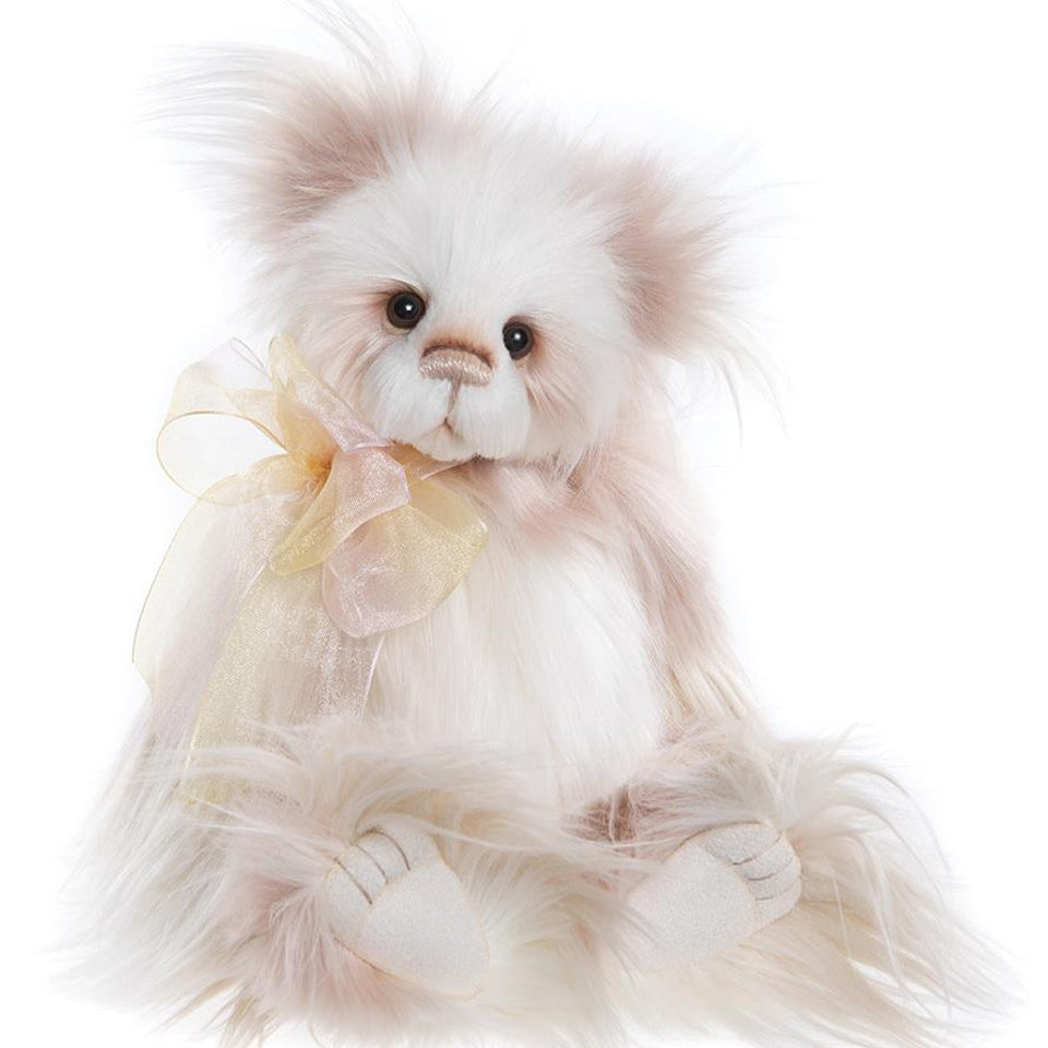 Charlie Bears Kaleena plush bear with long soft cream and blush fur, detailed paw pads, and a sheer golden bow.