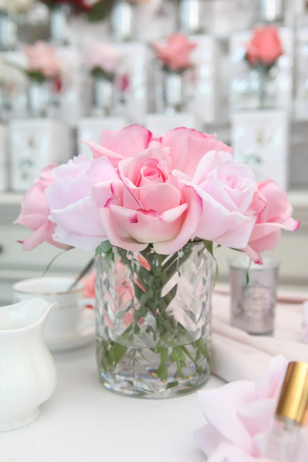 Pink mixed rose buds in a clear herringbone vase, Côte Noire artificial flower arrangement.