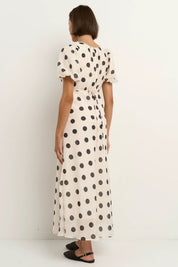Cream black polka dot maxi dress side sitting view feminine puff sleeve design gathered neckline fitted waist flowing skirt bias cut silhouette soft breathable tencel nylon blend fabric