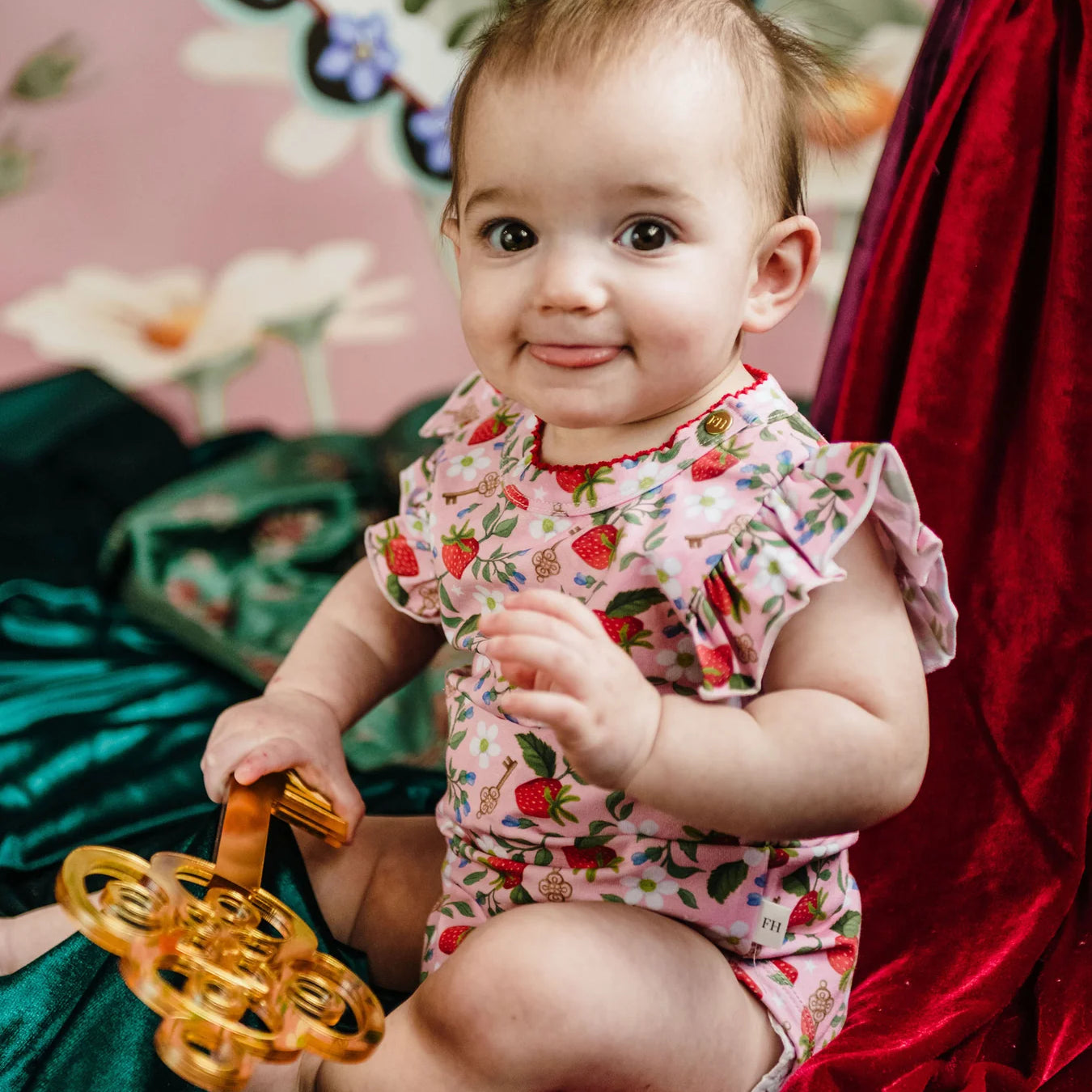 Baby girl wearing Fleur Harris Bijou Bodysuit in Hearts Floral print with frill sleeves from the All My Hearts collection.
