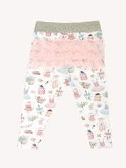 Flat lay of patterned leggings with gold waistband and layered pink frill tutu detail on back