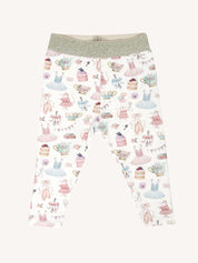 Flat lay of patterned leggings with gold waistband featuring party themed illustrations including dresses cakes and teacups