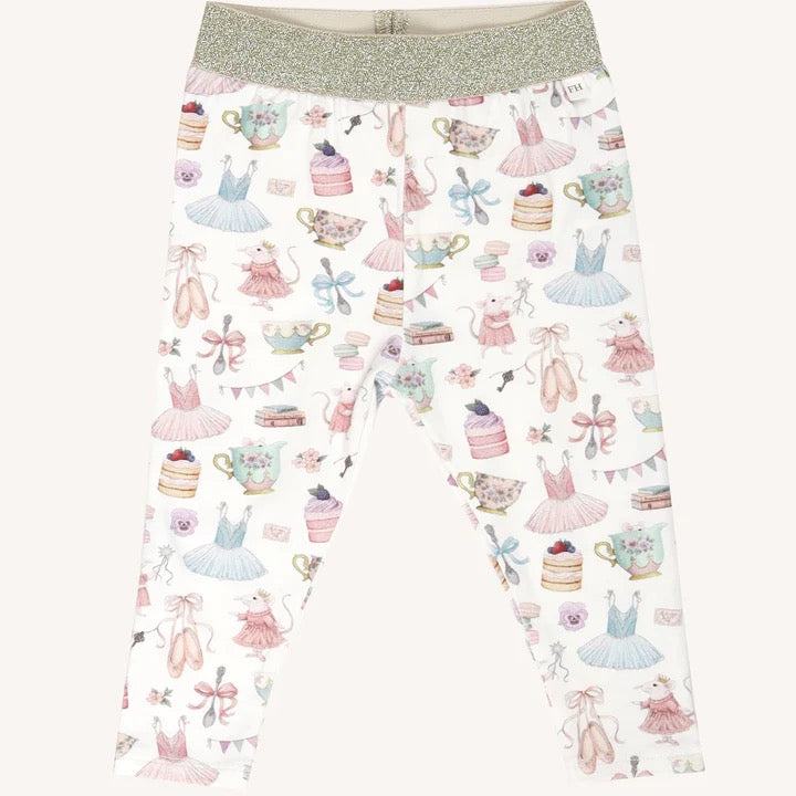 Flat lay of patterned leggings with gold waistband featuring party themed illustrations including dresses cakes and teacups