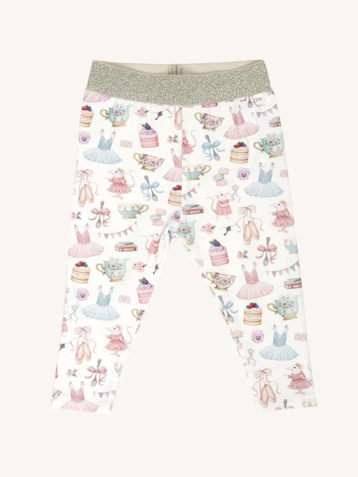 Flat lay of patterned leggings with gold waistband featuring party themed illustrations including dresses cakes and teacups