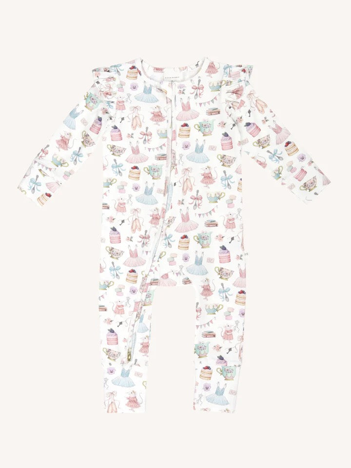 Flat lay of long sleeve frill coverall with all over print of party motifs ballet dresses cakes teapots and bunting