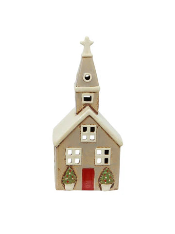 Front view of beige ceramic tea light church with red door, star-topped steeple, and Christmas trees at the entrance