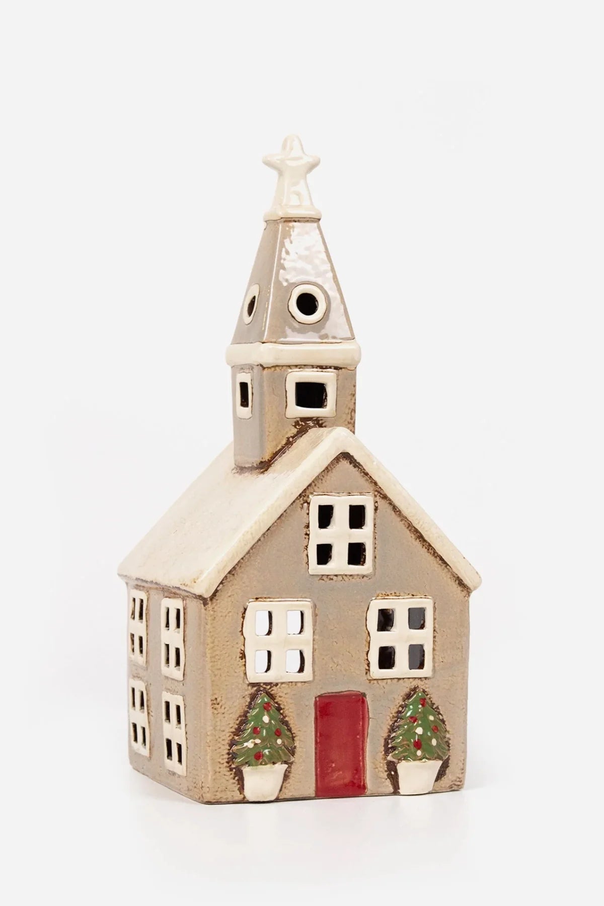 Beige ceramic tea light church with red door, white roof, and potted Christmas trees by the entrance