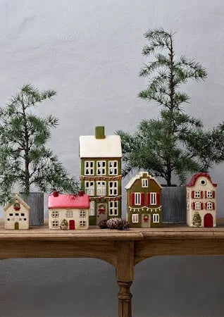 Display of French Country Alsace ceramic tea light cottages, including cream cottage with red shutters and red roof, styled with small Christmas trees