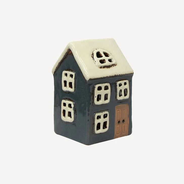 Side view of navy ceramic tea light house with white roof and window cutouts