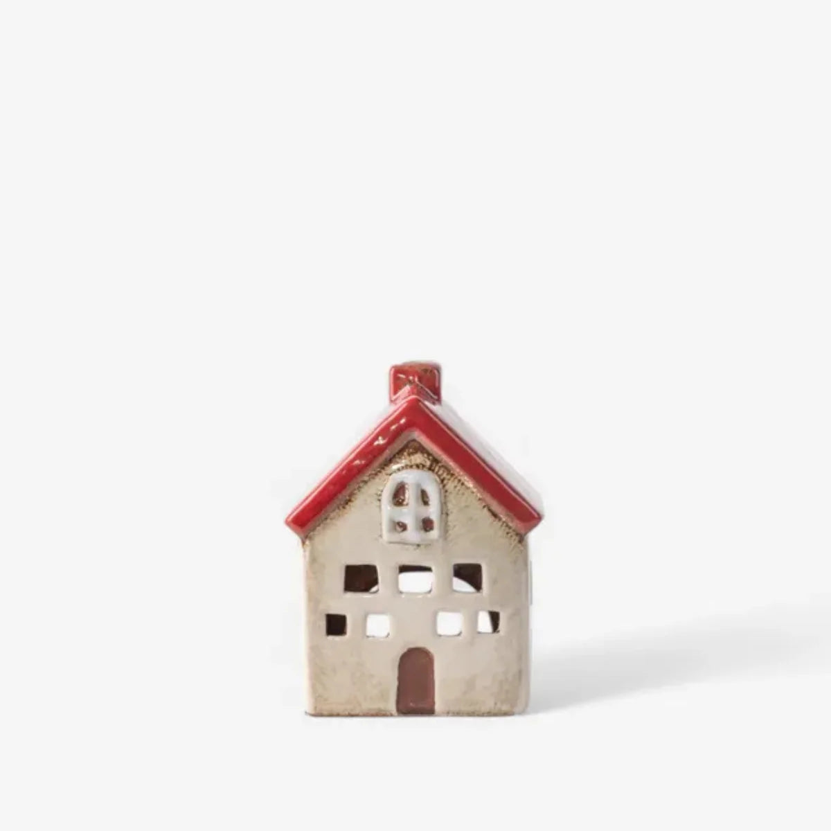 Front view of small ceramic tea light house in white with red roof and cut out windows