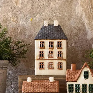 Styled display of French Country Cotswolds Country Tea Light Estate House with plants and other ceramic houses.