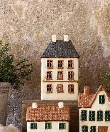Styled display of French Country Cotswolds Country Tea Light Estate House with plants and other ceramic houses.