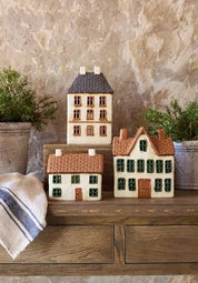 French Country Cotswolds Country Tea Light Estate House displayed on wooden table with other cottages and greenery.