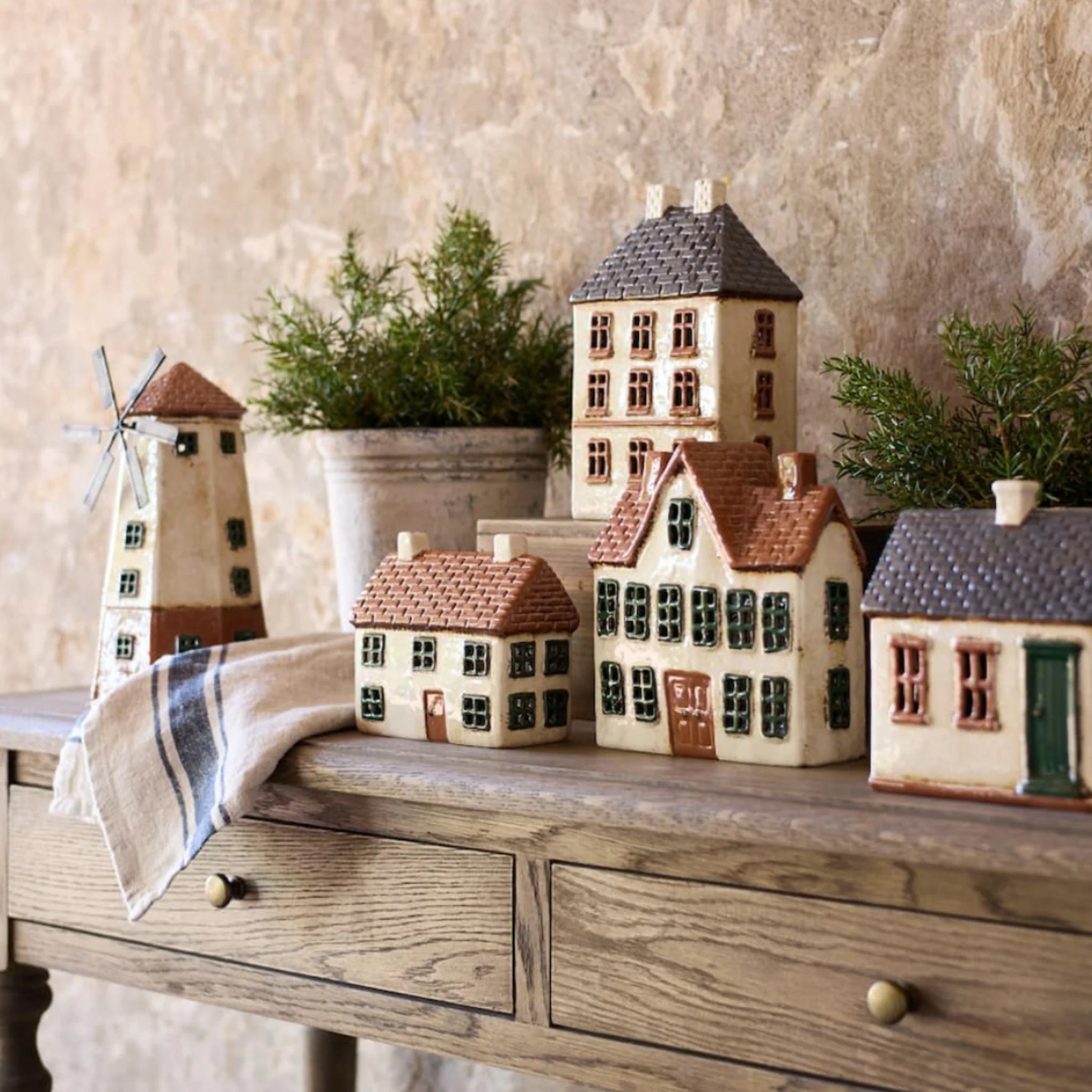 Collection of French Country Cotswolds Country Tea Light Houses including the Homestead, windmill, and estate houses arranged on a rustic table.