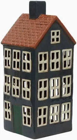 Tall ceramic tea light house in navy with terracotta roof and green door, featuring multiple window cutouts.