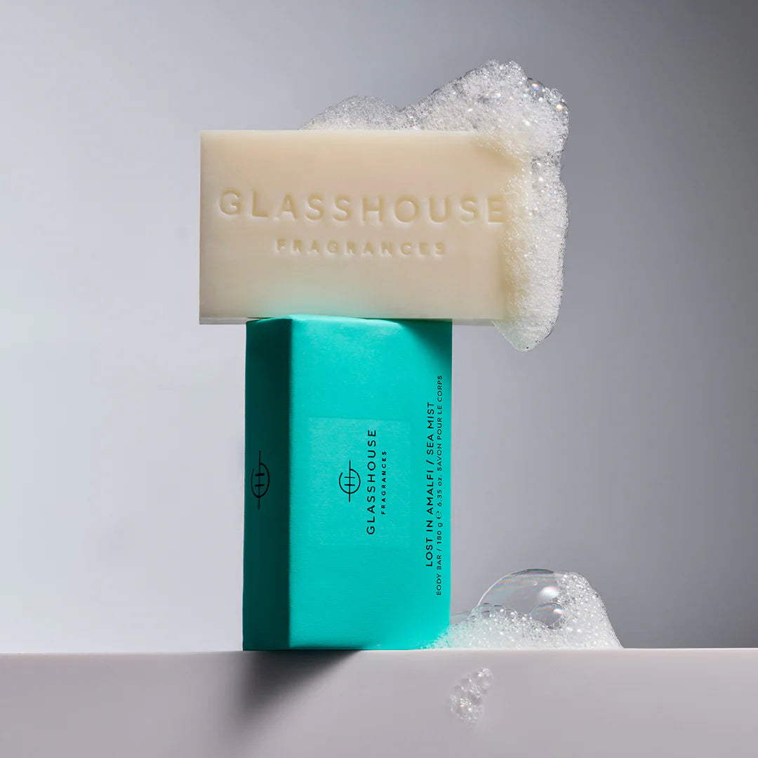  Sea Mist" 180g body bar with the cream-colored soap resting on top, covered in foamy soap bubbles.