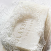 Close-up of Glasshouse Fragrances Midnight in Milan body bar covered in foamy soap bubbles.
