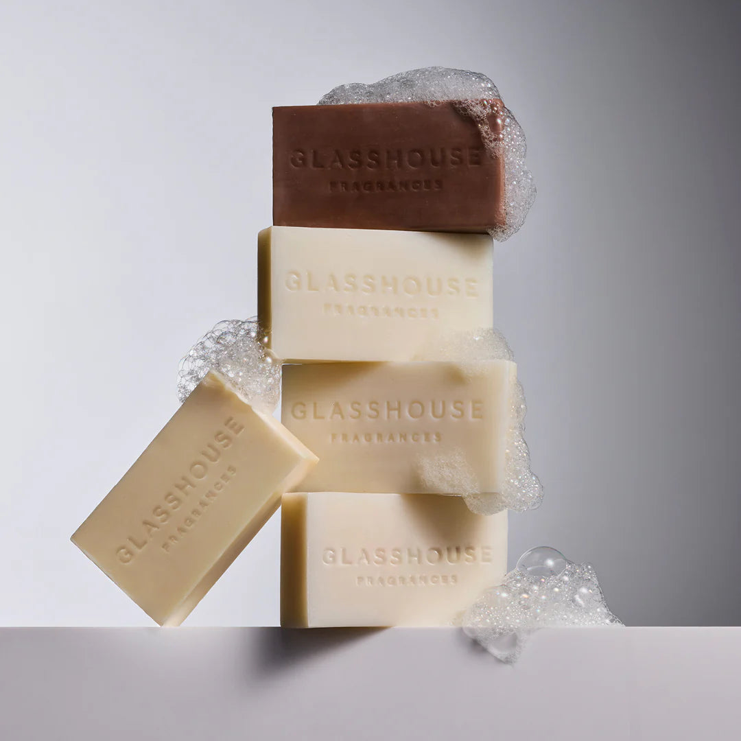 Stack of GLASSHOUSE body bars with bubbles, featuring the brown A Tahaa Affair Vanilla Caramel soap on top.