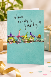 Close-up detail of Who's Ready to Party Birthday Card showing illustrated frogs in party hats