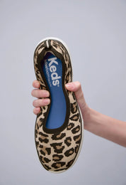Keds BlissWalk Skimmer Knit Leo Tan Black slip on sneakers flexible leopard print knit upper shown in hand demonstrating lightweight comfort cushioned BlissFoam Tech insole removable washable design casual women’s footwear