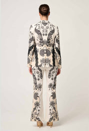 Back view of cream printed blazer with black bird and floral pattern paired with matching trousers