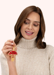 Model holding POWDER beaded toadstool keyring