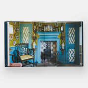 The New Antiquarians book interior showing historic home decor with blue fireplace and antiques